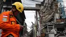 Petugas Basarnas berdiri dekat gedung yang ambruk di Jalan Brigjen Katamso, Kota Bambu Selatan, Palmerah, Jakarta Barat, Senin (6/1/2020). Tiga orang dilaporkan terluka akibat tertima material gedung empat lantai tersebut. (Liputan6.com/Johan Tallo)