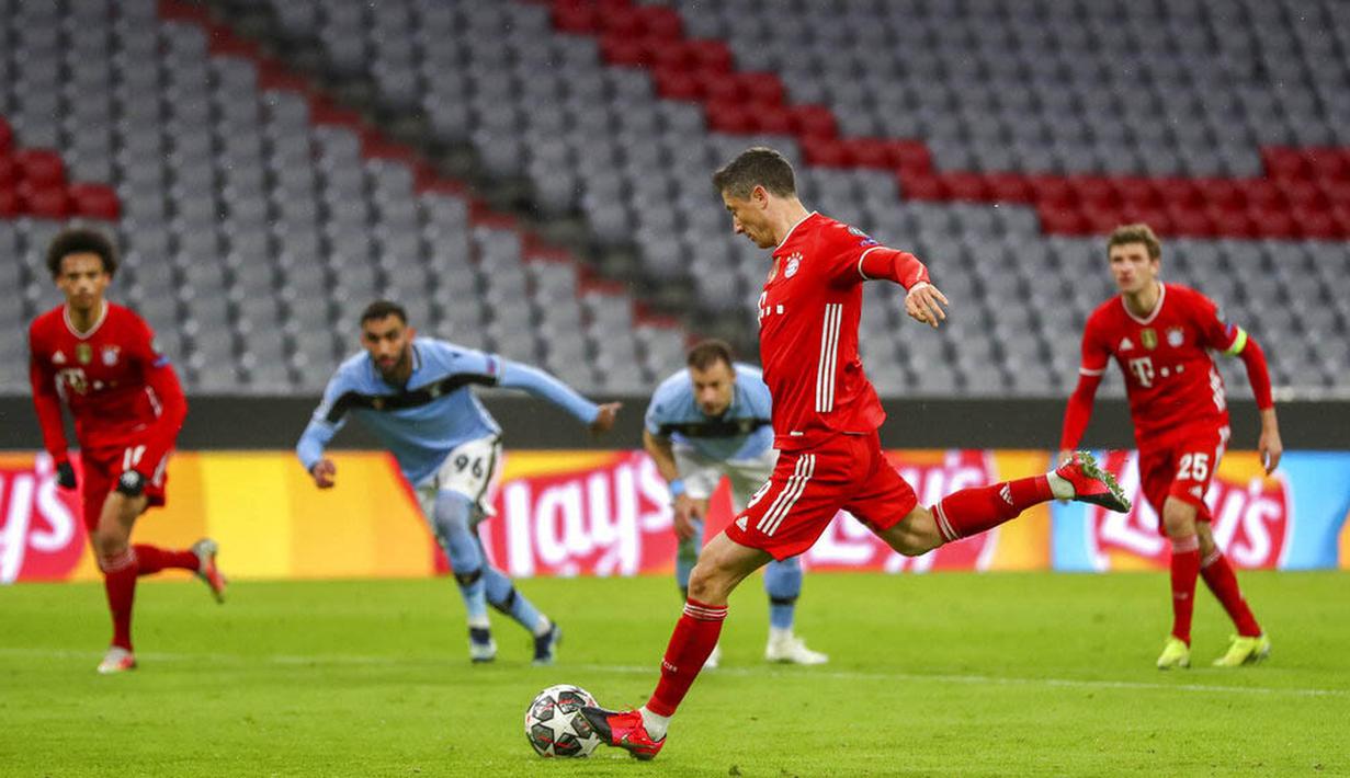 Striker Bayern Munchen, Robert Lewandowski, melepaskan tendangan penalti ke gawang Lazio pada laga Liga Champions di Allianz Arena, Kamis (18/3/2021). Bayern Munchen menang dengan skor 2-1. (AP Photo/Matthias Schrader)