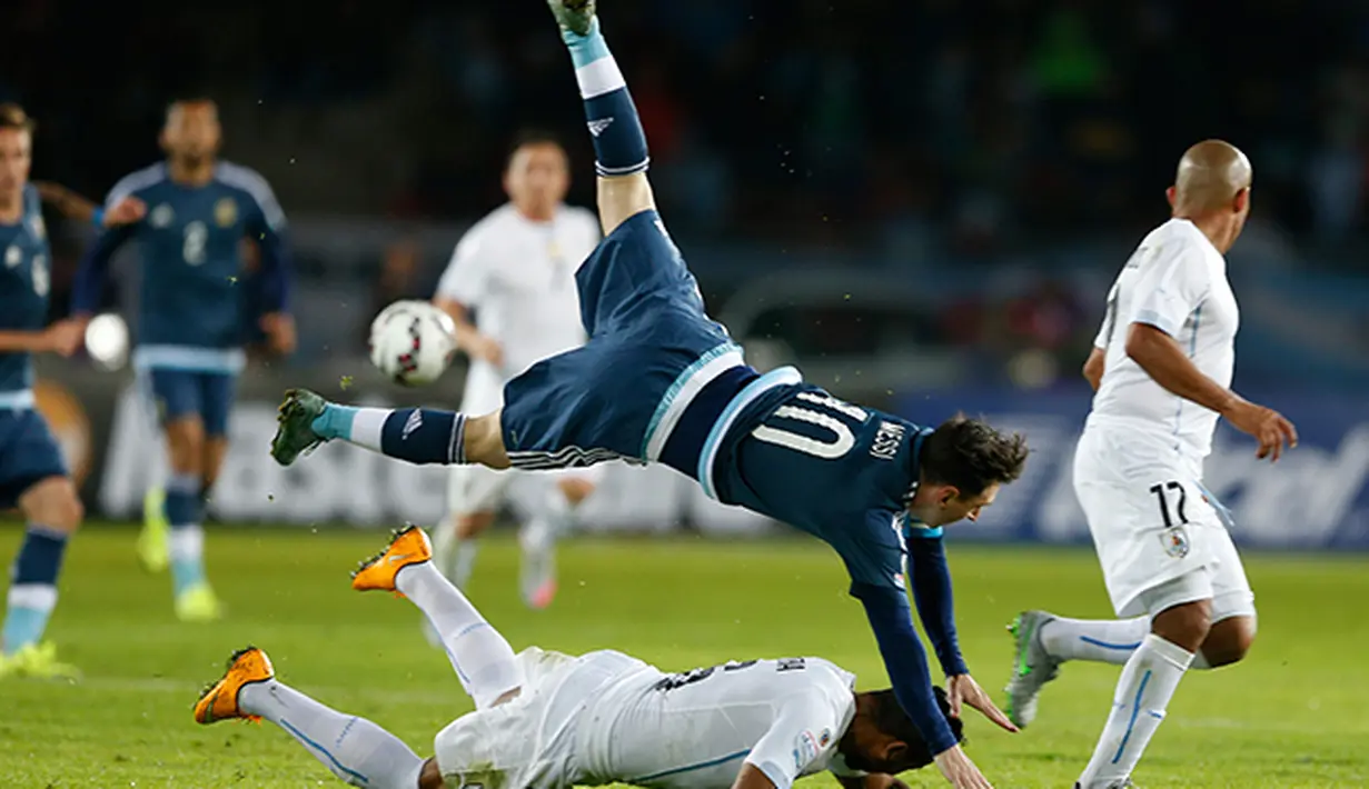 Lionel Messi terjungkal saat berduel dengan bek Uruguay Alvaro Pereira. (AP/Andre Penner)