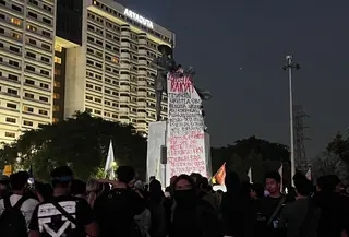 Sejumlah mahasiswa dan elemen masyarakat sipil membentangkan spanduk berukuran besar berisi lima tuntutan kepada pemerintahan Presiden Prabowo Subianto dan Wakil Presiden Gibran Rakabuming Raka di Monumen Tugu Tani, Jakarta Pusat, Selasa (20/10/2026). (Liputan6.com/Winda Nelfira)