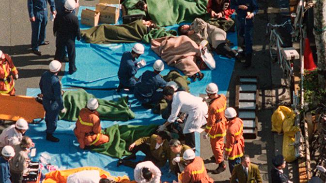 Tim penyelamat menolong korban serangan gas sarin oleh sekte kiamat Aum Shinrikyo di Tokyo, Jepang, 20 Maret 1995. Serangan itu mengejutkan Jepang, negara yang membanggakan dirinya dengan tingkat kejahatan rendah. (Kyodo News via AP, File)