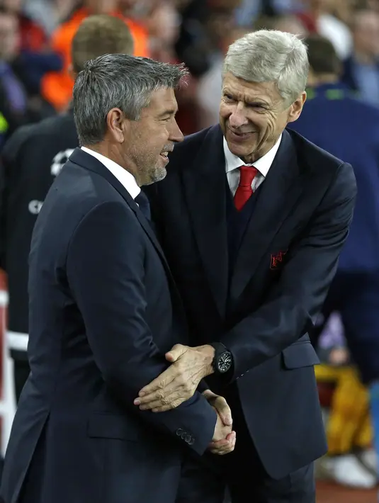 Pelatih Basel, Urs Fischer (kiri) bersalaman dengan pelatih Arsenal, Arsene Wenger  sebelum laga grup A Liga Champions di Emirates stadium, London, Kamis (29/9/2016)dini hari WIB. (AP/Alastair Grant)
