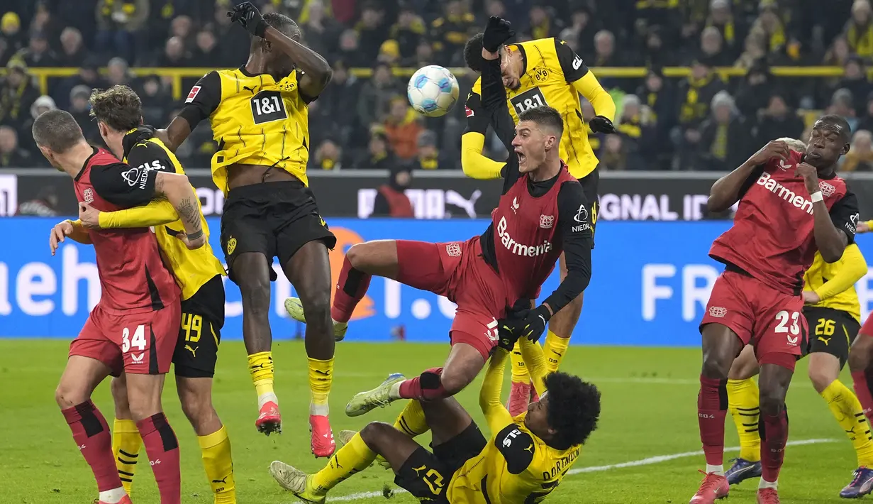 Pemain Bayer Leverkusen, Patrik Schick (tengah) berebut bola dengan pemain Borussia Dortmund, Karim Adeyemi pada laga lanjutan Bundesliga 2024/2025 di Signal Iduna Park, Dortmund, Jerman, Sabtu (11/01/2025) WIB. (AP Photo/Martin Meissner)