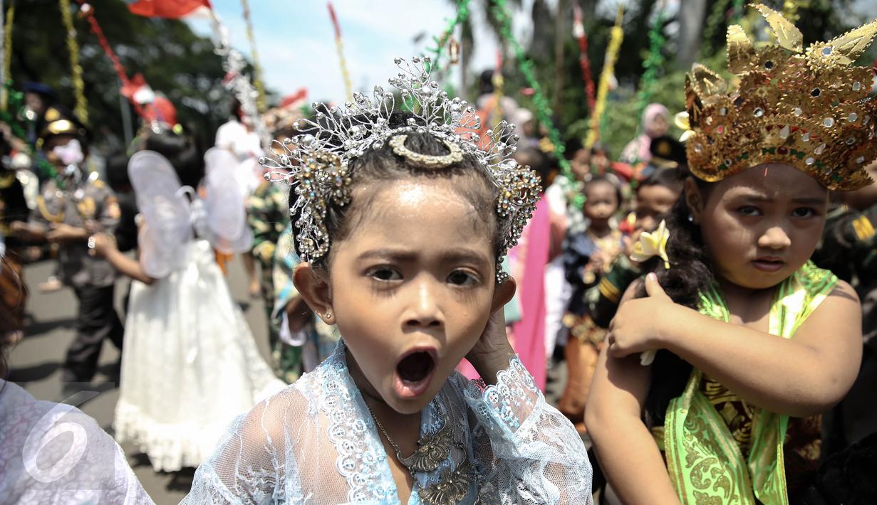 Seorang murid TK Sekolah Alternatif untuk Anak Jalanan (SAAJA) saat pawai sambil mengenakan pakaian adat, kawasan Kuningan, Jakarta, Kamis (21/4). Kegiatan diikuti sekitar 70 anak-anak kurang mampu di ibukota. (Liputan6.com/Faizal Fanani)