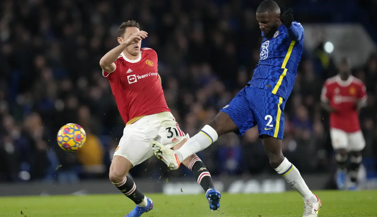 Gelandang Manchester United, Nemanja Matic berebut bola dengan pemain Chelsea, Antonio Rudiger selama pertandingan lanjutan Liga Inggris di di stadion Stamford Bridge, London, Senin (29/11/2021). Chelsea bermain imbang atas MU 1-1. (AP Photo/Kirsty Wigglesworth)