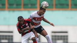 Pemain Madura United, Dodi Alekvan Djin (kanan) dan pemain Persipura Jayapura, Yohanes Pahabol berduel udara dalam laga pekan ke-6 BRI Liga 1 2021/2022 di Stadion Wibawa Mukti, Cikarang, Minggu (03/10/2021). (Bola.com/Bagaskara Lazuardi)