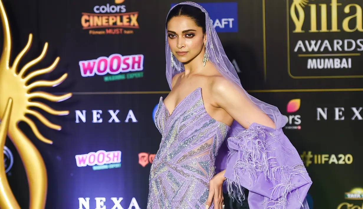Aktris Bollywood, Deepika Padukone berpose saat menghadiri International Indian Film Academy (IIFA) ke-20 di NSCI Dome di Mumbai (19/9/2019). Deepika tampil cantik mengenakan gaun bulu berwarna ungu dengan kerudung panjang dan anting-anting besar. (AFP Photo/Punit Paranjpe)