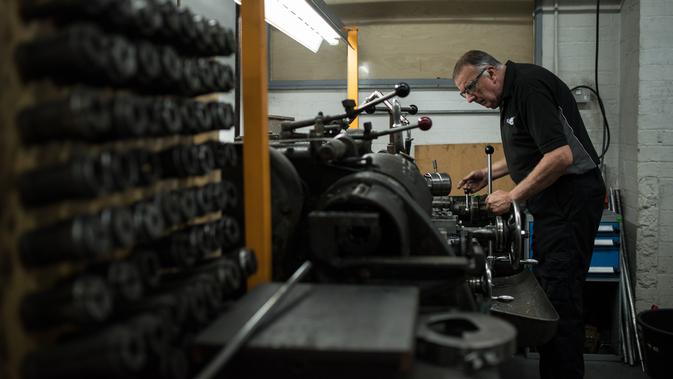 Pekerja membuat komponen mesin mobil klasik sport di pabrik mobil Morgan Motor Company di Malvern, Birmingham, Inggris (13/8/2019). Morgan Motor Company telah memproduksi kendaraan klasik Inggris selama lebih dari 105 tahun. (AFP Photo/Oli Scarff)