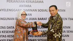 Direktur Komersial PT Bank BJB, Tbk Suartini (kiri) dan Direktur Keuangan dan Investasi BPJS Kesehatan Kemal Imam Santoso (kanan) bertukar cinderamata usai penandatanganan kerjasama, Jakarta, Rabu (22/11). (Liputan6.com/Angga Yuniar)