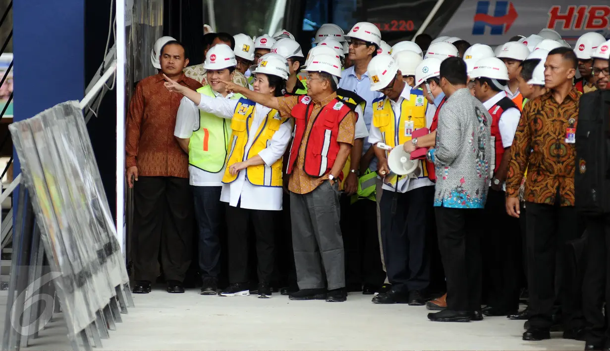 Wakil Presiden, Jusuf Kalla (rompi merah) melihat gambar perkembangan proyek renovasi Stadion Gelora Bung Karno, Jakarta, Minggu (26/3). Peninjauan ini terkait persiapan pelaksanaan Asian Games 2018 mendatang. (Liputan6.com/Helmi Fithriansyah)
