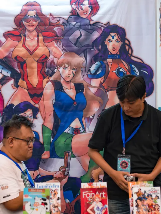 Pengunjung melihat komik yang di pajang saat Festival Pop Culture Popcon Asia 2018 di BSD, Tangerang Selatan, Sabtu (22/9). (AFP PHOTO / BAY ISMOYO)