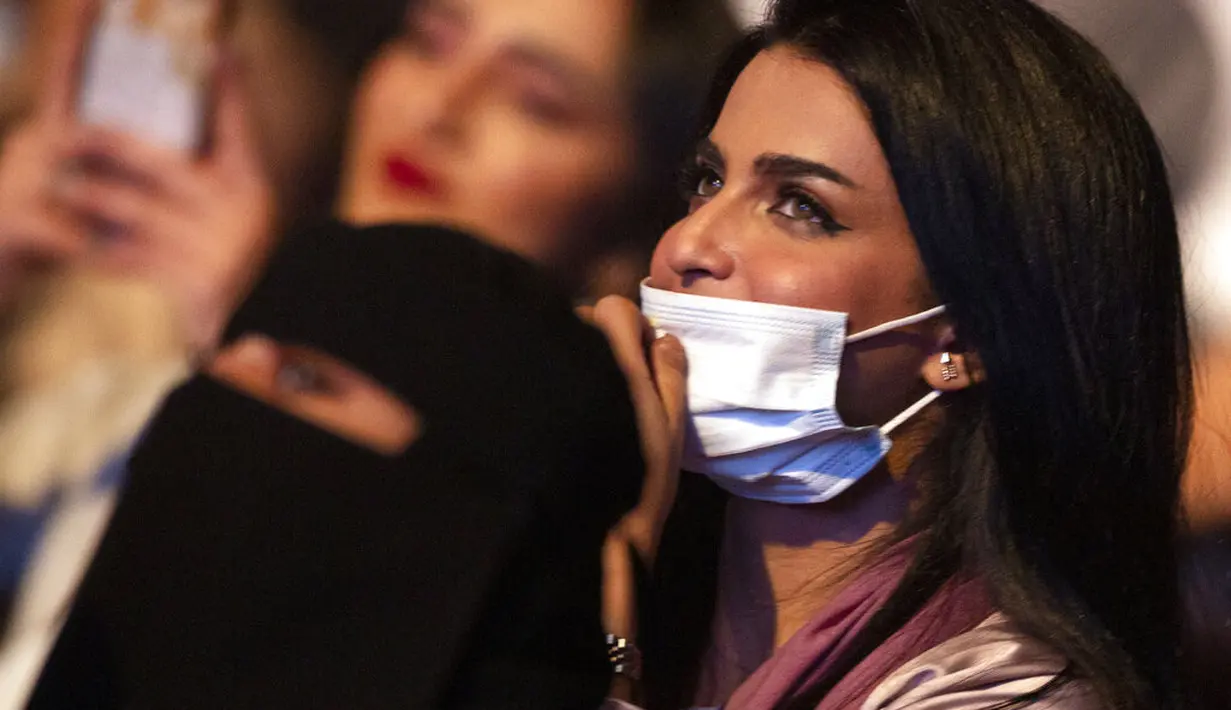 Seorang wanita yang telah divaksinasi virus corona menonton penyanyi Saudi Mohammed Abdu di Super Dome di Jeddah, Arab Saudi (8/7/2021). Konser ini diselenggarakan Otoritas Hiburan Umum Saudi setelah kerajaan mencabut pembatasan virus corona pada acara di bulan Mei. (AP Photo/Amr Nabil)