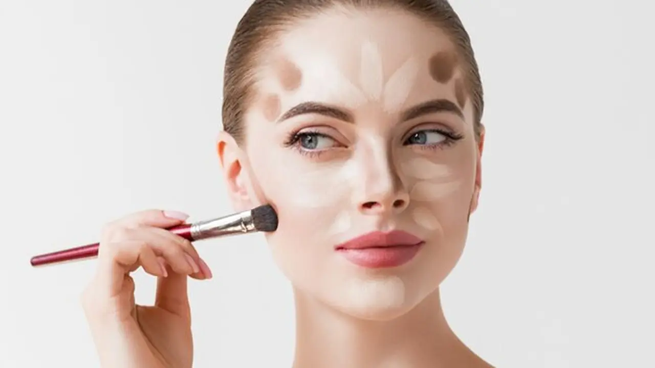 Seorang perempuan sedang mengaplikasikan contour di wajahnya menggunakan brush make up (Foto Dok: Freepik/kiraliffe)