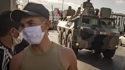 Tentara Maroko berpatroli di tengah wabah baru virus corona baru di kota Tangiers (11/8/2020). Tentara dikerahkan untuk meredam Lonjakan kasus Covid-19 di negara tersebut. (AFP/Fadel Senna)