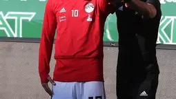 Pemain timnas Mesir Mohamed Salah dibantu tim kesehatan melatih bahunya yang cedera saat pelatihan di stadion Akhmat Arena di Grozny (12/6). Timnas Mesir berada di grup bersama Uruguay, Arab Saudi dan Rusia. (AFP Photo/Karim Jaafar)