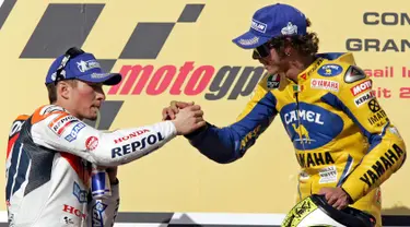 Nicky Hayden (kiri) dari tim America of Honda berjabat tangan dengan Valentino Rossi dari tim Yamaha Italia saat berada di podium usai laga Qatar MotorGP di Sirkuit Losail, di Doha, Qatar, Sabtu (8/4/2006). (AP Photo / Kamran Jebreili)