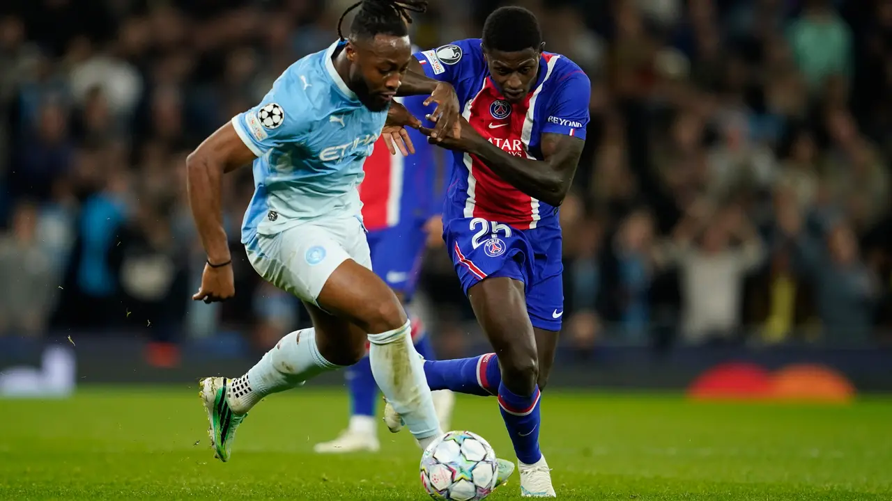 Pemain Manchester City Antoine Semenyo (kiri) berebut bola dengan pemain PSG Nuno Mendes