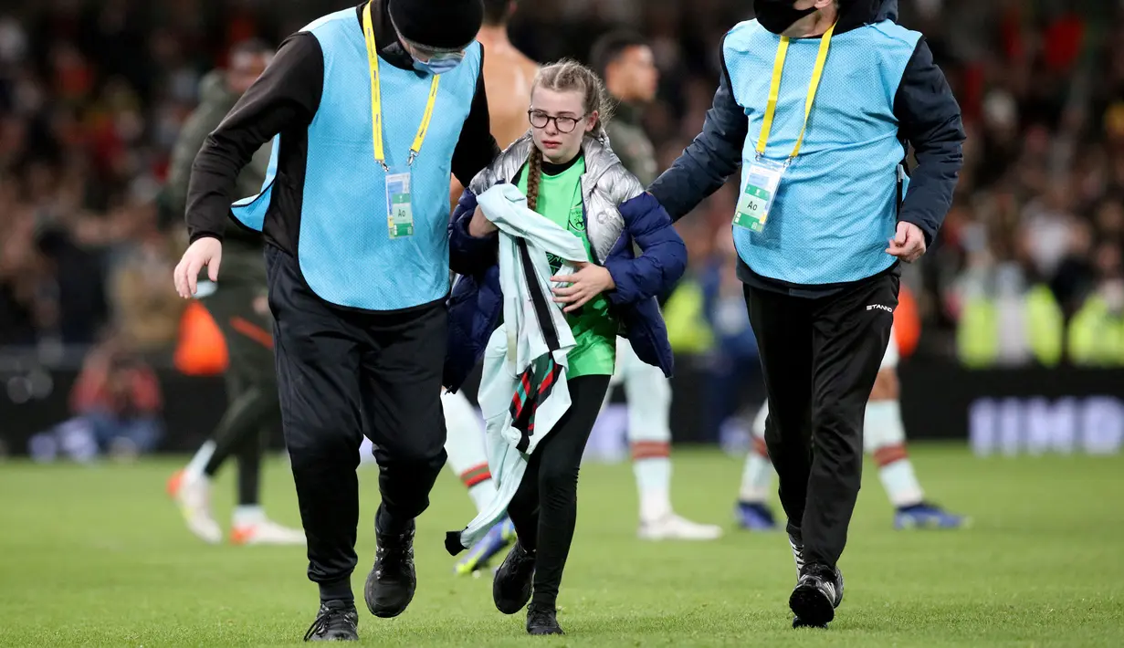 Fans cilik tersebut akhirnya digiring ke luar lapangan oleh petugas keamanan dengan ekspresi haru sambil memegang erat-erat jersey idolanya tersebut. (AFP/Paul Faith)