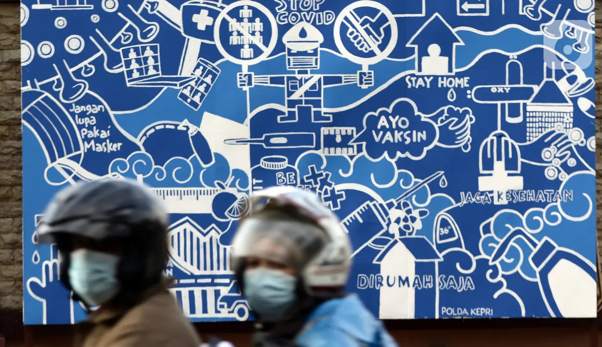 Pengendara melintas di depan mural protokol kesehatan COVID-19 di Jakarta, Minggu (21/11/2021). Untuk mencegah lonjakan kasus Covid-19, pemerintah akan menerapkan kebijakan PPKM Level 3 untuk seluruh wilayah Indonesia selama masa libur Natal 2021 dan Tahun Baru 2022.(Liputan6.com/Helmi Fithriansyah)