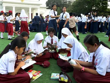 Sejumlah murid sekolah dasar tengah membaca buku di halaman Istana, Jakarta, Rabu (17/8). Sebanyak 500 pelajar menikmati membaca dan mendengarkan dongeng di halaman istana untuk memperingati Hari Buku Nasional. (Liputan6.com/Angga Yuniar)
