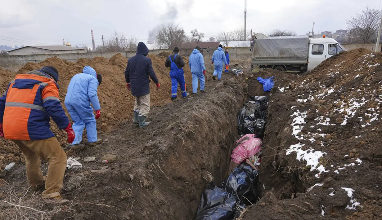 Sejumlah jenazah dimasukkan ke dalam kuburan massal di pinggiran Mariupol, Ukraina, 9 Maret 2022. Warga tidak dapat menguburkan orang mati di antara mereka karena serangan berat oleh pasukan Rusia. (AP Photo/Evgeniy Maloletka)