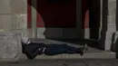 Seorang pria beristirahat di alun-alun Plaza Mayor di pusat kota Madrid, Kamis (10//2/2022). Warga Spanyol untuk pertama kalinya dalam hampir dua bulan diperbolehkan tidak menggunakan masker di luar ruangan setelah peraturan terkait hal itu dicabut pada Kamis. (AP Photo/Manu Fernandez)