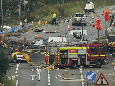 Tim penyelamat dan petugas investigasi berada di lokasi jatuhnya jet Hawker Hunter di Jalan Raya A27, Shoreham, Inggris, Minggu (23/8/2015). Pesawat yang tengah mengikuti Shoreham Airshow tersebut menewaskan sedikitnya tujuh orang.(REUTERS/Luke MacGregor)