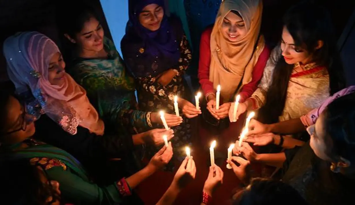 Sejumlah wanita Bangladesh menghadiri nyala lilin untuk memperingati Hari Perempuan Internasional di Dhaka (7/3). Hari Perempuan Internasional secara resmi dijadikan sebagai hari libur nasional di Soviet Rusia pada tahun 1917. (AFP Photo/Munir Uzzaman)