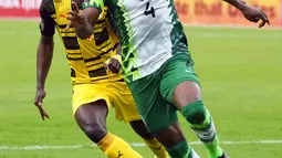 Pemain Nigeria Frank Onyeka (kanan) berebut bola dengan pemain Ghana pada pertandingan sepak bola leg kedua kualifikasi Piala Dunia 2022 di Abuja, Nigeria, 29 Maret 2022. Pertandingan berakhir imbang 1-1. (AP Photo/Sunday Alamba)