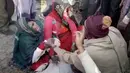 Keluarga menangis di atas jasad korban kecelakaan antara bus sekolah dan truk di Etah, negara bagian Uttar Pradesh, India, Kamis (19/1). Butuh satu jam untuk mengevakuasi jenazah dan juga korban luka-luka dari badan bus yang ringsek (KK Production via AP)