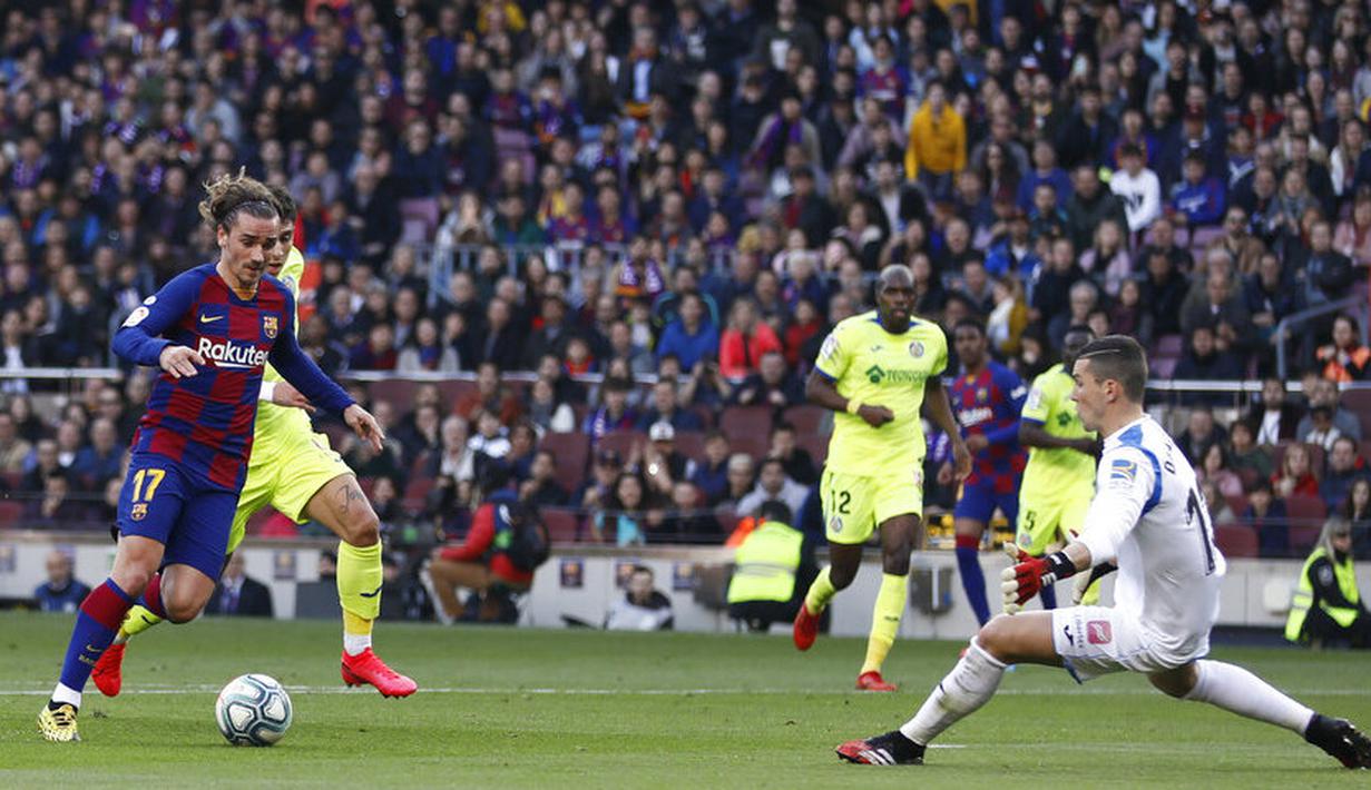 Penyerang Barcelona, Antoine Griezmann, berusaha melewati kiper Getafe, David Soria, pada laga La Liga di Stadion Camp Nou, Sabtu (15/2/2020). Barcelona menang 2-1 atas Getafe. (AP/G.Garin)
