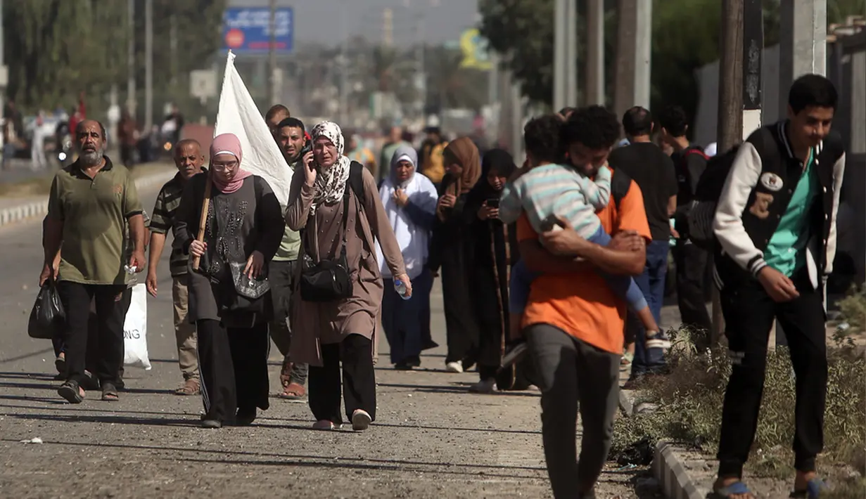 Seorang wanita membawa bendera putih untuk mencegah penembakan saat warga Palestina meninggalkan Kota Gaza ke Jalur Gaza selatan di Jalan Salah al-Din, Bureij, Selasa (7/11/2023). (AP Photo/Mohammed Dahman)