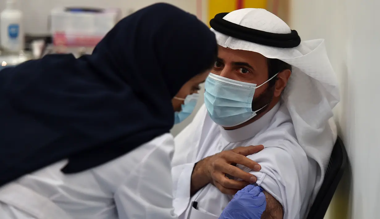 Seorang warga menjalani penyuntikan vaksin Covid-19 di pusat vaksinasi yang diawasi Kementerian Kesehatan Arab Saudi di Riyadh, Arab Saudi (17/12/2020). Arab Saudi merupakan salah satu negara pertama yang mengumumkan rencana implementasi program vaksinasi COVID-19 nasional.  (AFP/Fayez Nureldine)