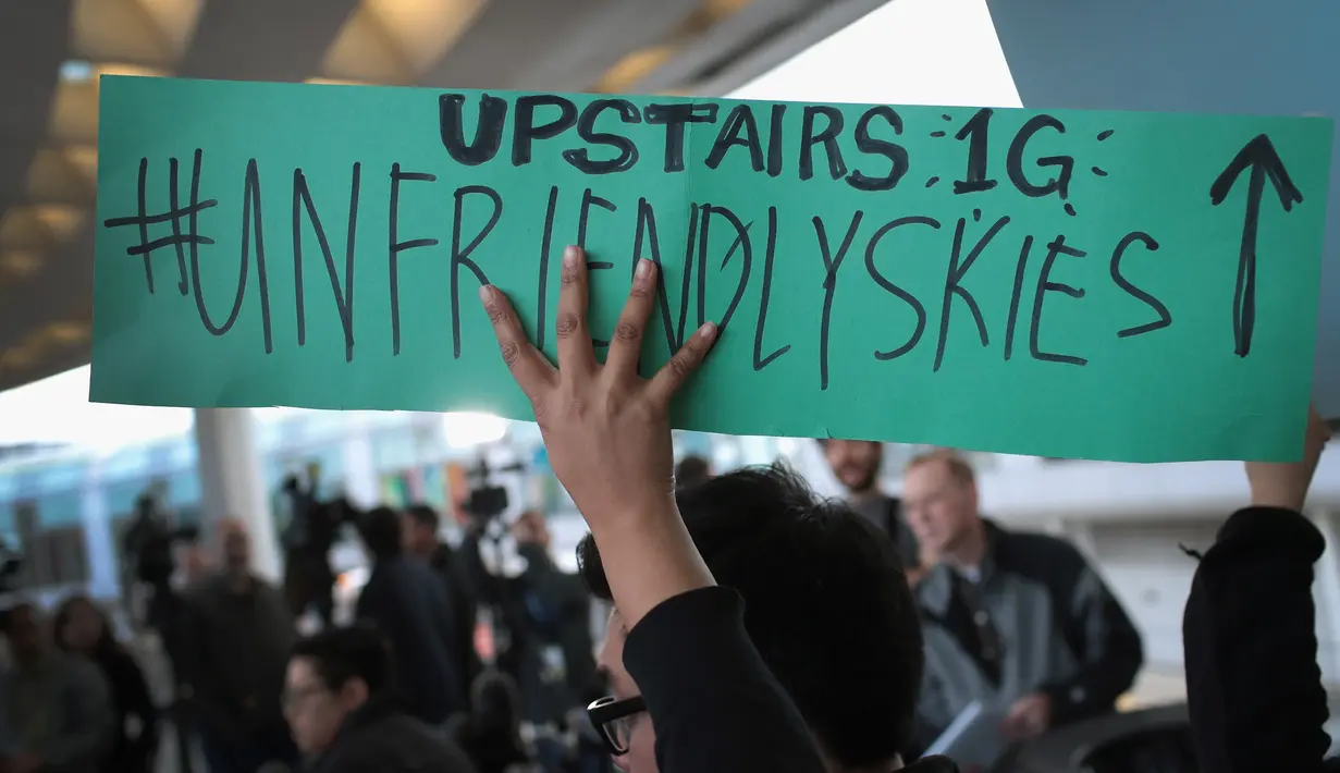 Demonstran mengecam tindakan polisi yang mengeluarkan penumpang tidak manusiawi di pesawat United Airlines di Bandara Internasional O'Hare, Chicago, AS, Selasa (11/4). (Scott Olson / Getty Images / AFP)