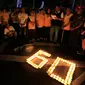 Sejumlah karyawan Artha Graha mengikuti aksi "Earth Hour" dengan menyalakan lilin membentuk angka 60 di kawasan SCBD Jakarta saat lampu-lampu di kawasan itu mulai dipadamkan selama satu jam pada Sabtu malam (19/3/2016). (Foto: Istimewa)