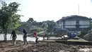 Anak-anak bermain dekat pengerukan lumpur di Waduk Setu, Cipayung, Jakarta, Rabu (28/7/2021). Pengerukan lumpur ini juga bagian dari proses menjadikan Waduk Setu sebagai kawasan agrowisata komersil yang akan dikelola pihak swasta. (merdeka.com/Iqbal S. Nugroho)