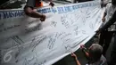 Seorang pria membubuhkan tanda tangan di spanduk putih guna dukungan untuk Rizal Ramli sebagai bakal calon gubernur DKI 2017, Jakarta, Senin (8/8). Aksi tersebut dilakukan oleh Konferederasi Serikat Pekerja Indonesia (KSPI). (Liputan6.com/Faizal Fanani)