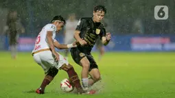 Pemain PSIS Semarang, Alfeandra Dewangga Santosa (kanan), berebut bola dengan pemain PSM Makassar, Erwin Gutawa, dalam laga Perempatfinal Piala Menpora 2021 di Stadion Kanjuruhan, Malang, Jumat (9/4/2021). PSIS vs PSM berakhir dengan skor 2-4 via adu tendangan penalti. (Bola.com/Arief Bagus)