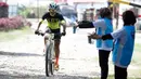 Petugas memberikan minuman kepada pebalap sepeda saat ambil bagian dalam kejuaraan Mountain Bike Cross Country Marathon (MTB XCM) di Kawasan Tanjung Lesung, Pandeglang, Banten, Sabtu (29/9). (Liputan6.com/HO/Nick)