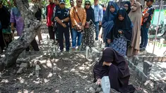 Bibi (kanan bawah) dari penyelam Syachrul Anto yang meninggal dunia kala melakukan evakuasi jatuhnya pesawat Lion Air PK-LQP, berdoa saat pemakaman di Surabaya, Jawa Timur, Sabtu (3/11). Syachrul Anto meninggal karena dekompresi. (JUNI KRISWANTO/AFP)