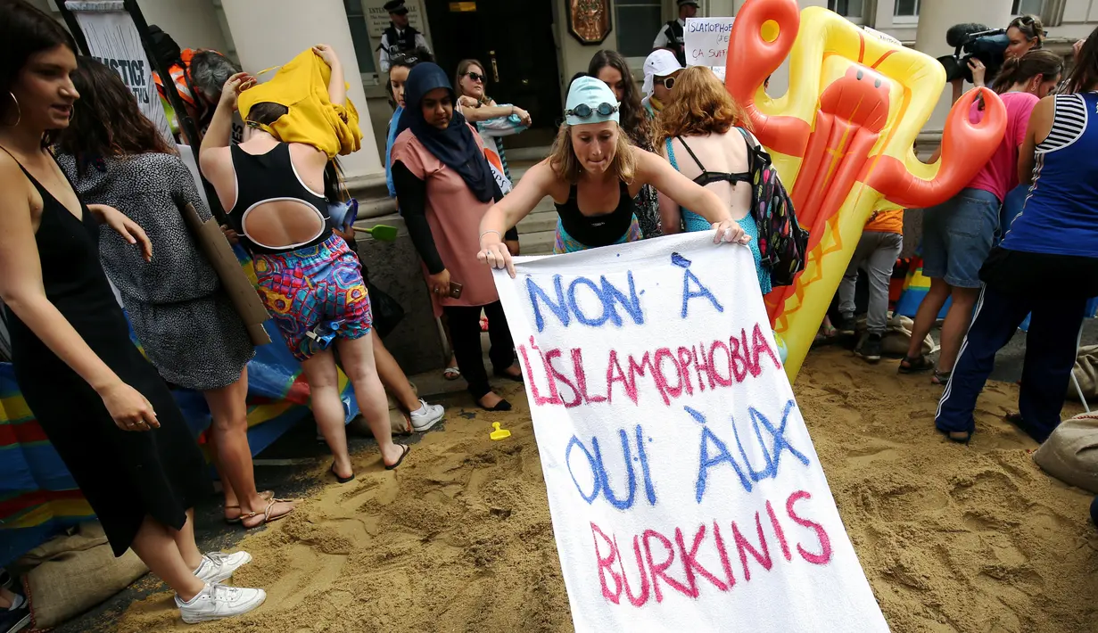Sejumlah wanita mengadakan demonstrasi pesta pantai di luar kedutaan Prancis di London, Inggris, Kamis (25/8). Mereka memprotes larangan burkini (pakaian renang muslimah) yang diberlakukan di beberapa kota pesisir di Prancis. (REUTERS/Neil Hall)