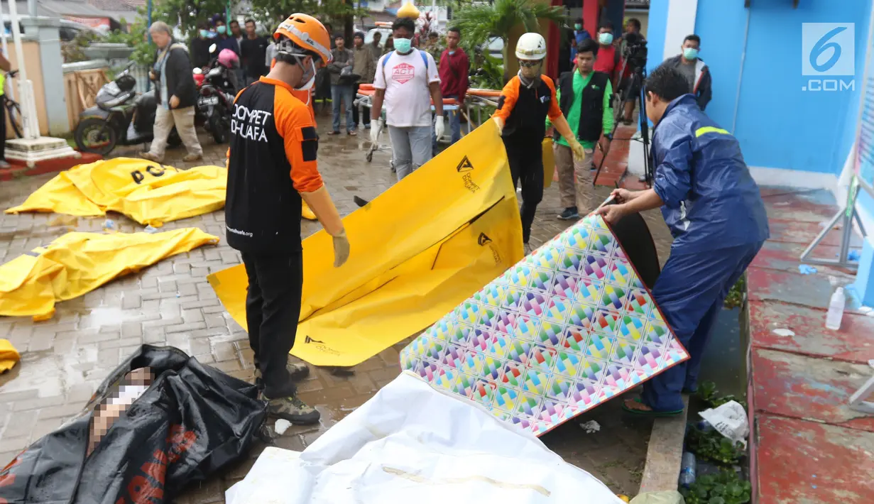 Petugas gabungan menyiapkan kantong jenazah di Puskesmas Carita, Banten, Minggu (23/12). Tim SAR masih melakukan pencarian jenazah yang sebagian besar berasal dari Pantai Carita. (Liputan6.com/Angga Yuniar)