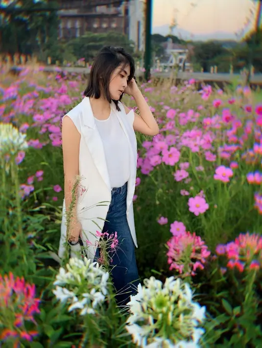 Ketika tengah berlibur, Eva Anindita tampil stylish dengan gaya kasual. Aktris sekaligus model itu mengenakan tank top putih yang dipadukan dengan outer senada dan celana jeans panjang. (Liputan6.com/IG/@eva_anindita_zachrie)