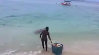 Seorang wanita terekam kamera sedang membuang sampah ke laut. Foto: (Screenshoot)