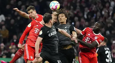 Pemain Freiburg Nicolas Hoefler (depan) dan Kiliann Sildillia (kedua kanan) berebut bola udara dengan pemain Bayern Munich Dayot Upamecano (kanan) dan Leon Goretzka pada pertandingan perempat final DFB Pokal 2022/2023 di Stadion Allianz Arena, Munich, Jerman, Selasa (4/4/2023). Freiburg menang 2-1. (AP Photo/Matthias Schrader)