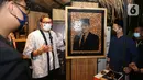 Menteri Parekraf Sandiaga Uno melihat salah satu karya pada acara Apresiasi Kreasi Indonesia (AKI) 2021 di Gandaria City, Jakarta, Kamis (9/12/2021). AKI 2021 yang telah berjalan di 16 kota dengan mengangkat tema ‘Produk Indonesia untuk Ekonomi Kuat’. (Liputan6.com/Fery Pradolo)
