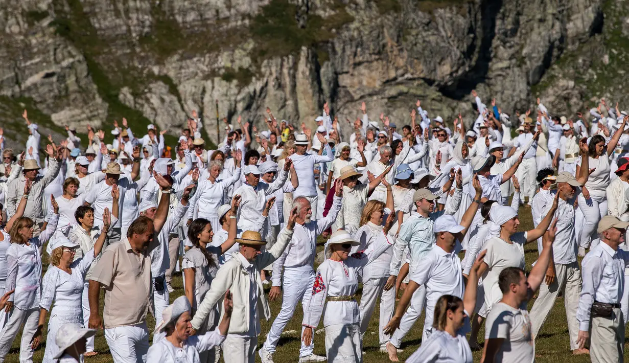 Anggota gerakan keagamaan internasional White Brotherhood menari di puncak Gunung Rila, Bulgaria, Senin (19/8/2019). Tarian tersebut ditampilkan dalam lingkaran konsentris yang mereka yakini dapat menghubungkannya dengan ritme kosmik dan melawan kesedihan. (NIKOLAY DOYCHINOV/AFP)