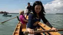 Gabriella Lazzari, anggota Row Venice, mengajarkan mendayung gondola bagi wisatawan di sebuah kanal di Venesia, Italia pada 16 Mei 2019. Pengalaman ini bisa dimiliki dengan sekitar Rp 1,37 juta per gondola selama 90 menit untuk empat orang yang dimulai pukul 10.00 pagi. (MARCO BERTORELLO/AFP)