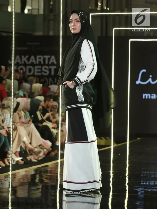 Model membawakan busana rancangan Lina Sukijo saat Jakarta Modest Fashion Week di Gandaria City, Jakarta, Minggu (29/7). (Liputan6.com/Herman Zakharia)