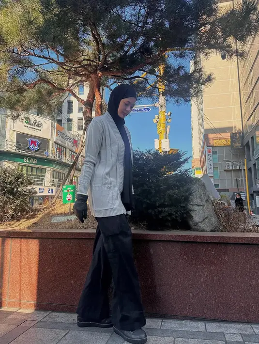 Ia nampak kenakan long sleeve hitam dipadu dengan outer cardigan dan celana kargo. Lengkapi busananya, Paula kenakan hijab pashima, sepatu, dan sarung tangan hitam [@paula_verhoeven]